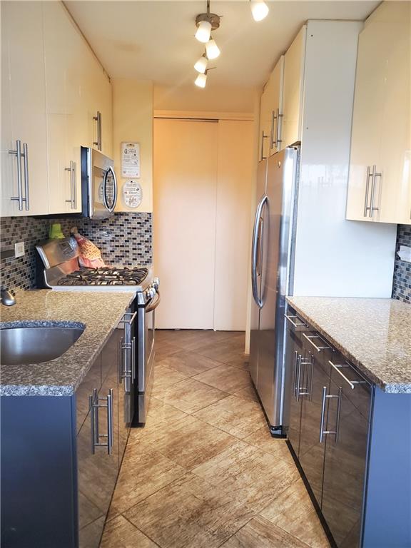 a kitchen with stainless steel appliances granite countertop a sink and a refrigerator