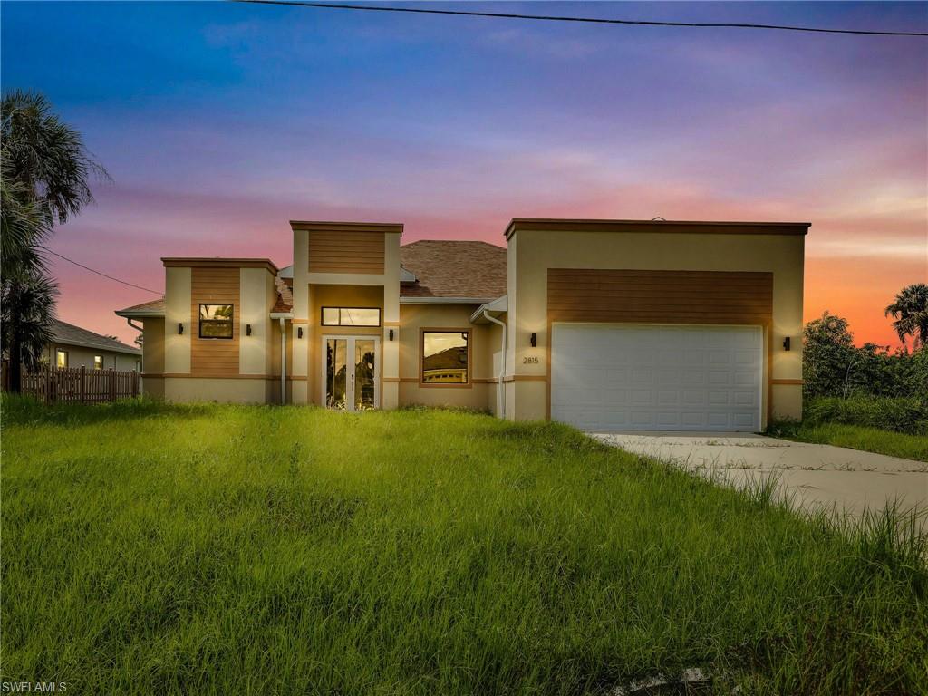 a front view of a house with a yard and garage