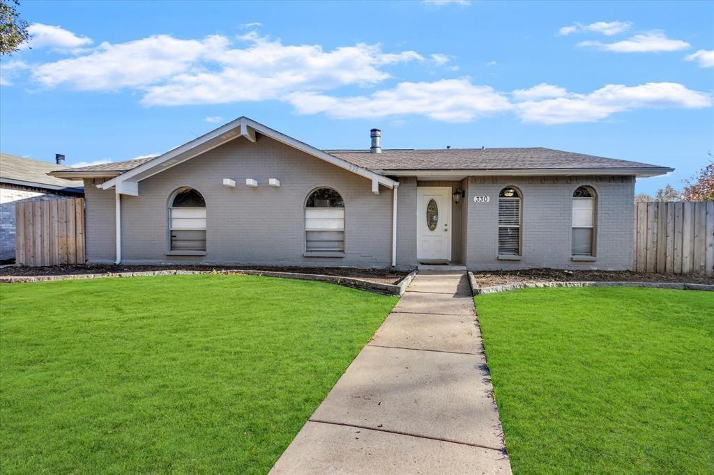 a front view of a house with a garden and yard