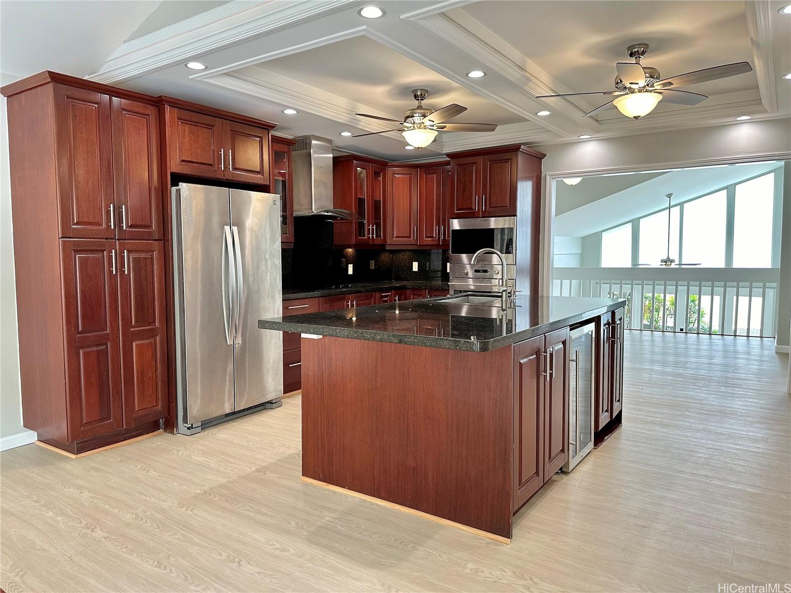 a kitchen with stainless steel appliances granite countertop a refrigerator a sink dishwasher and a large refrigerator