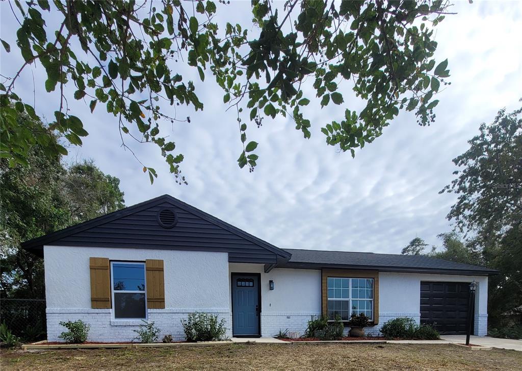 a front view of a house with a tree