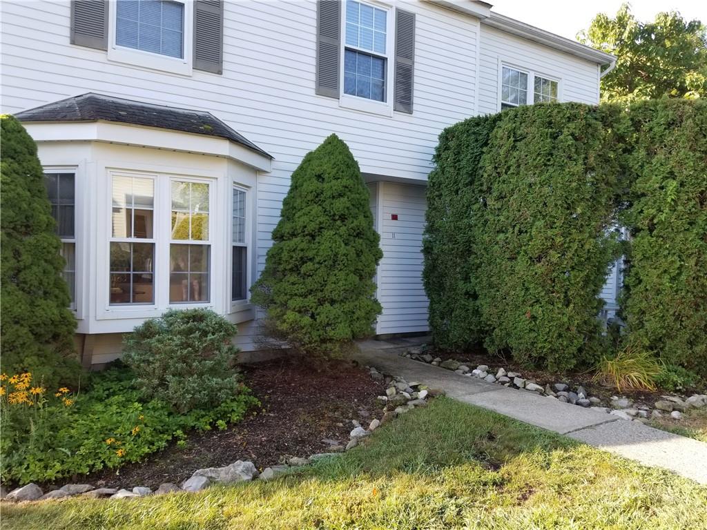 a view of a house with potted plants and a large tree