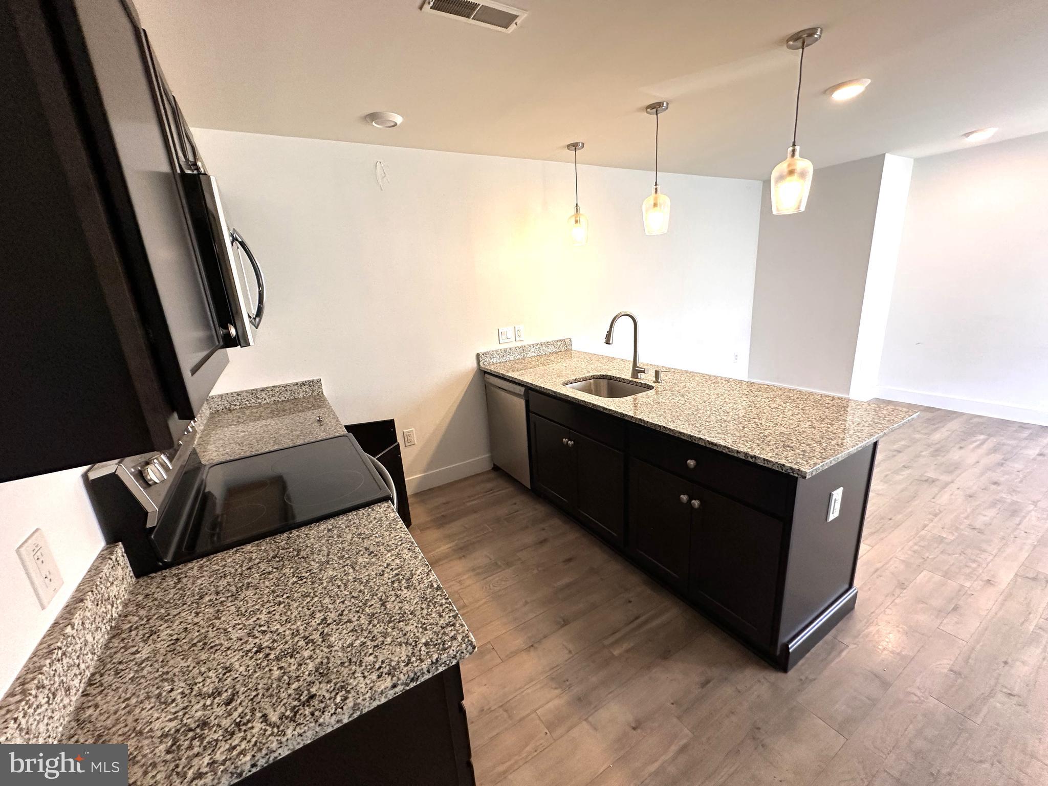 a spacious bathroom with a granite countertop sink a toilet a mirror and vanity