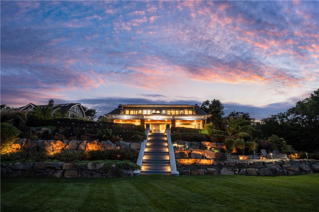 Back house at dusk featuring a yard