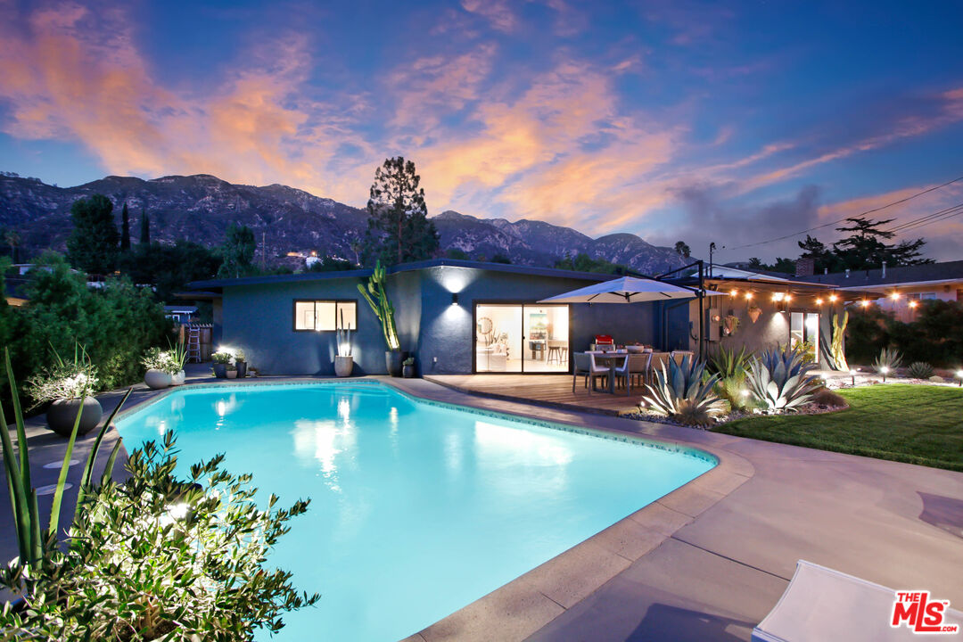 a view of a house with swimming pool and a yard