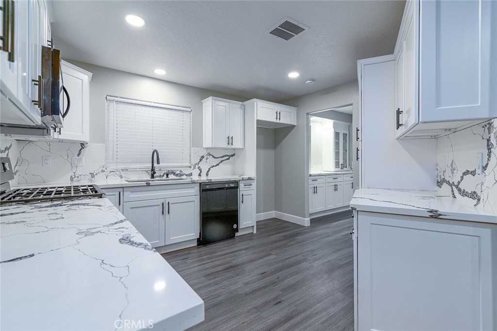 a kitchen with a sink stainless steel appliances and white cabinets