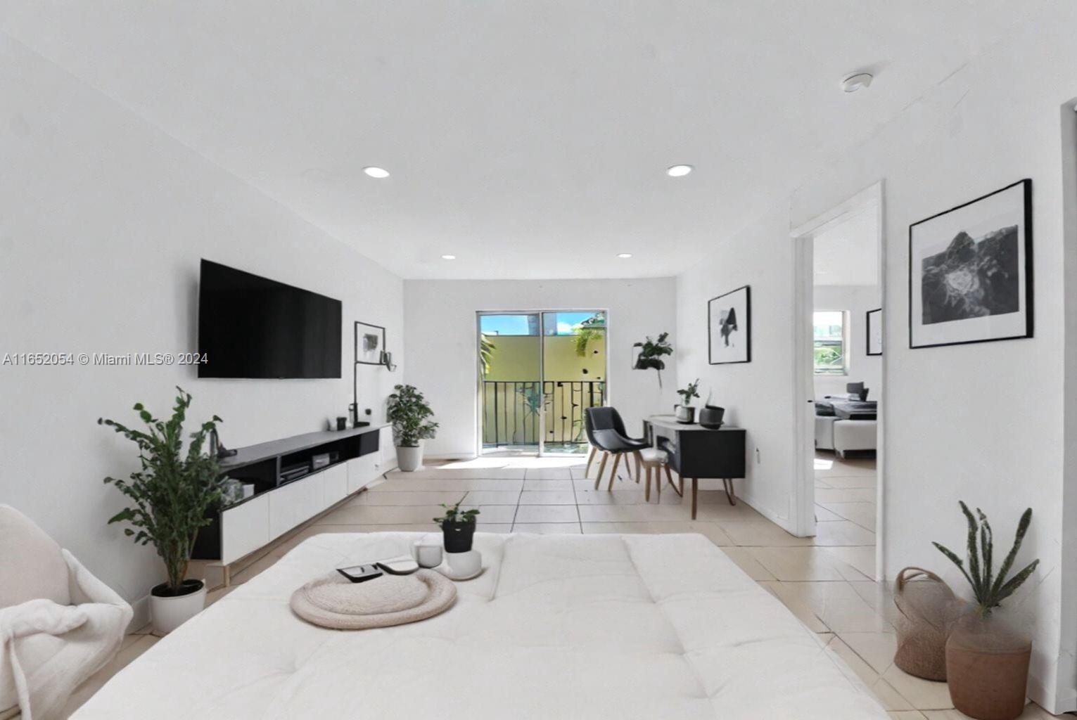 a living room with furniture potted plant and a flat screen tv