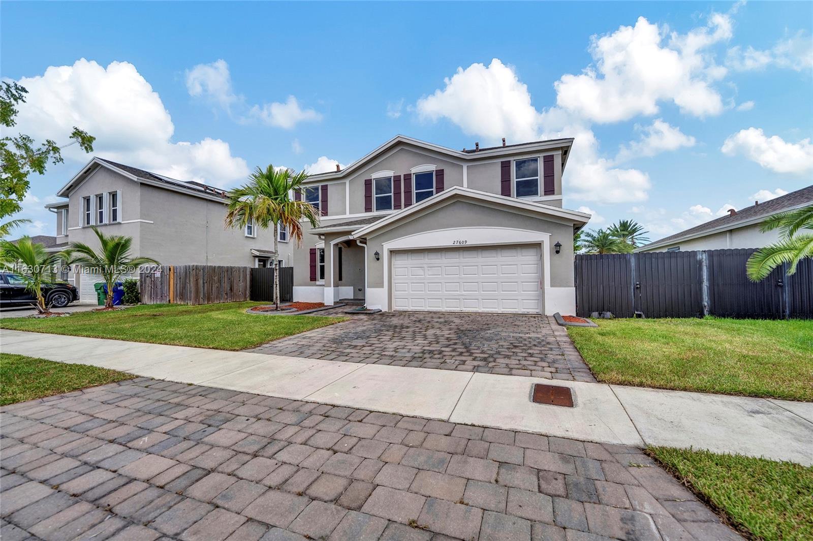 a front view of a house with a yard and a garage