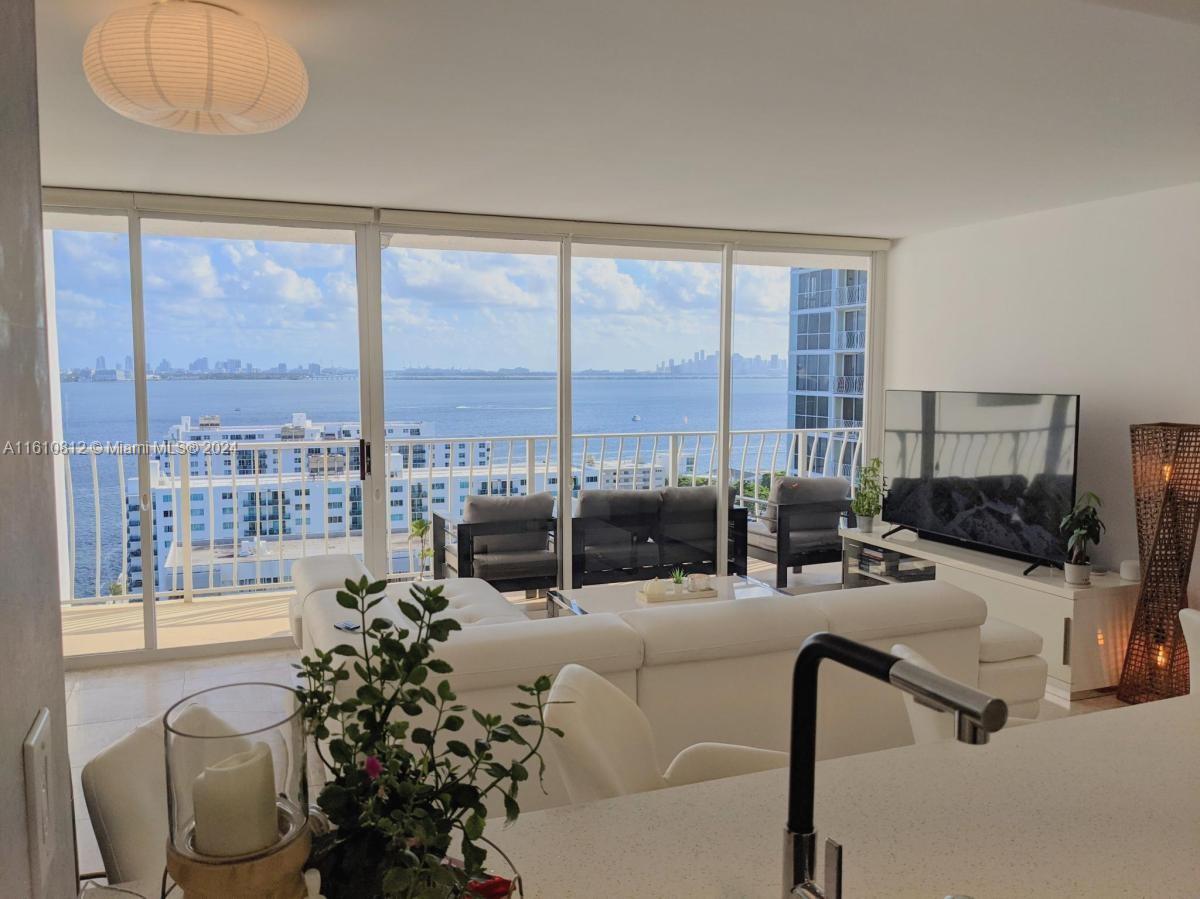 a living room with furniture and a floor to ceiling window