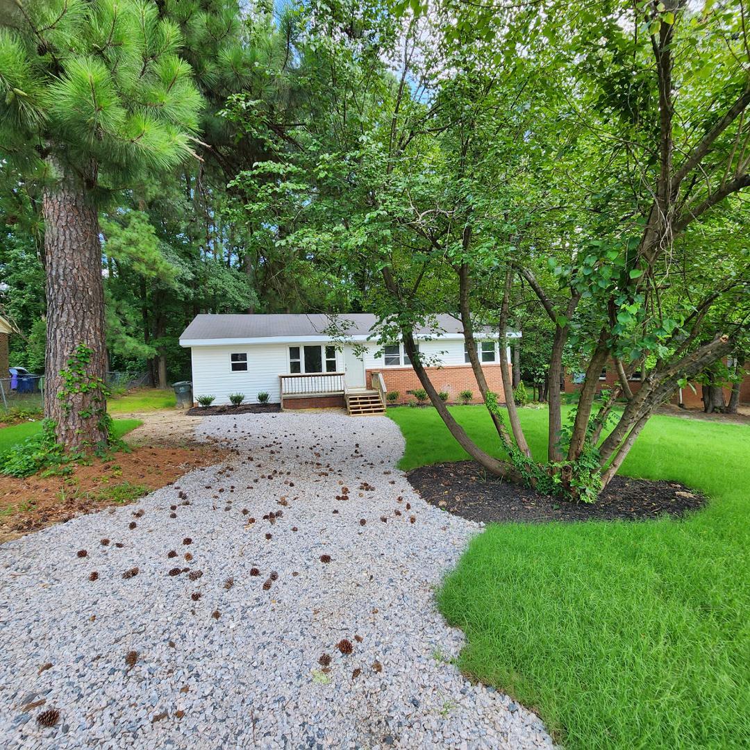 a front view of a house with a yard and trees