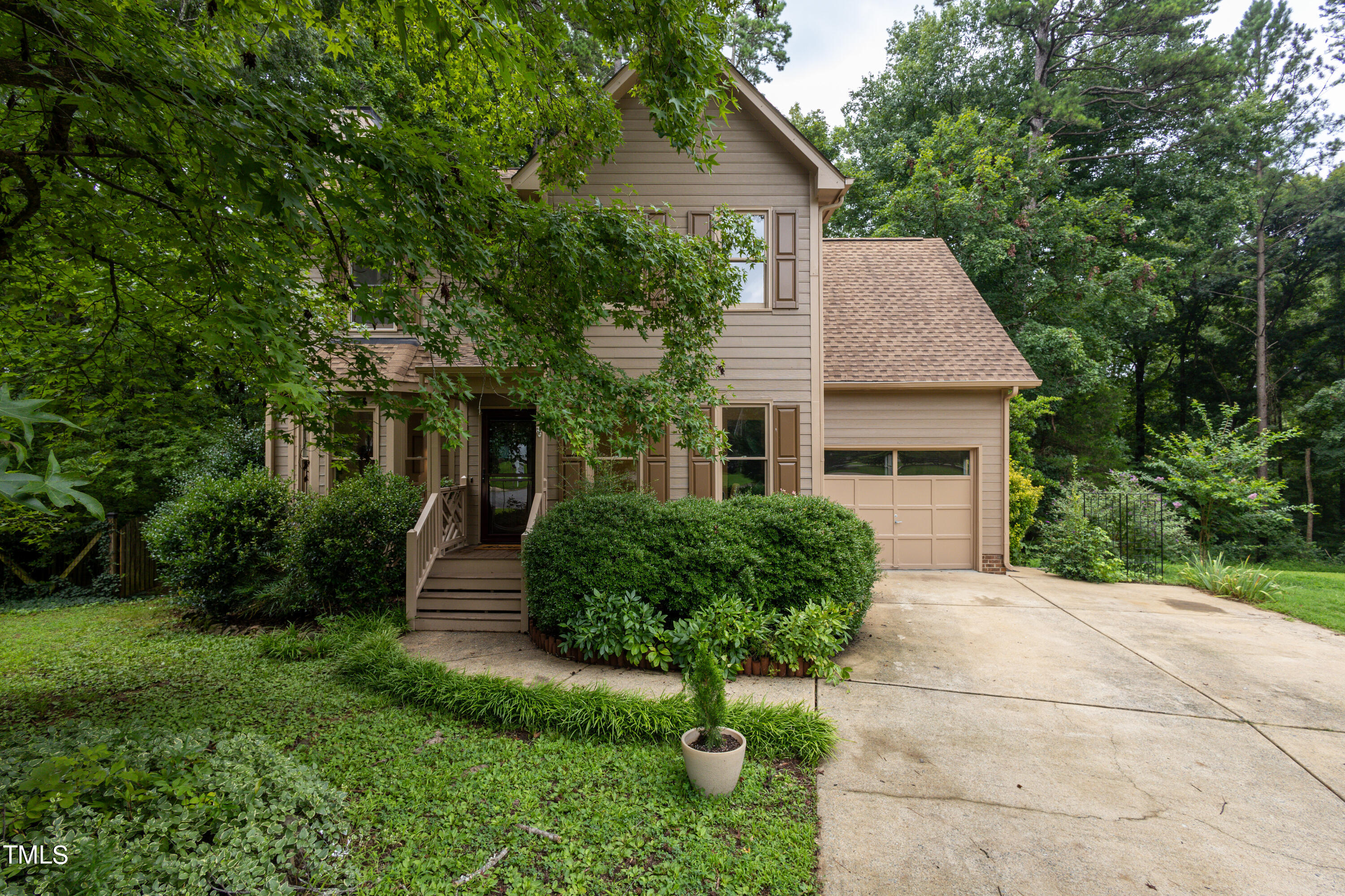 a front view of a house with a yard and potted plants