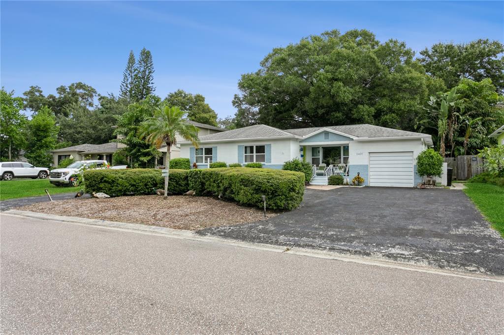 a front view of a house with a yard and trees