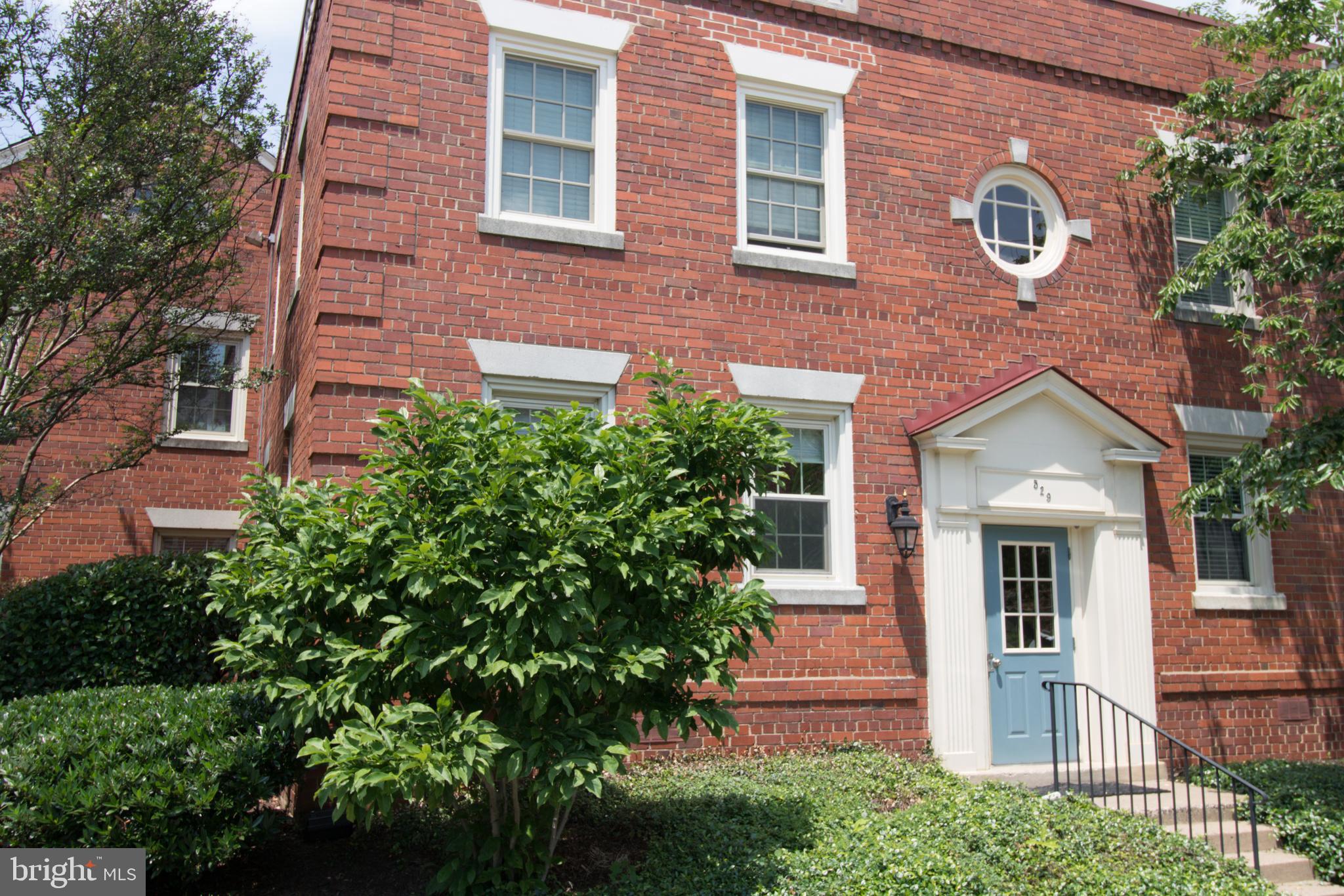 a front view of a house with plants