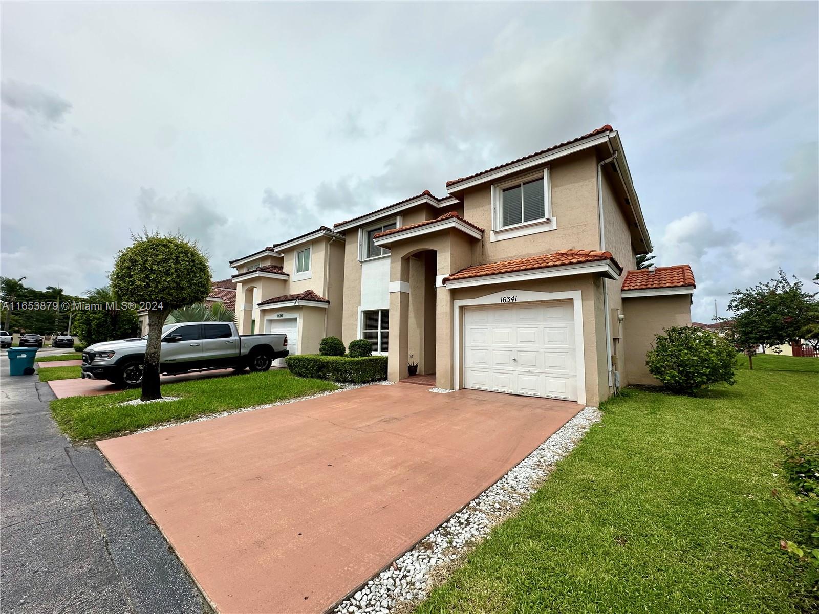 a front view of a house with a yard and garage