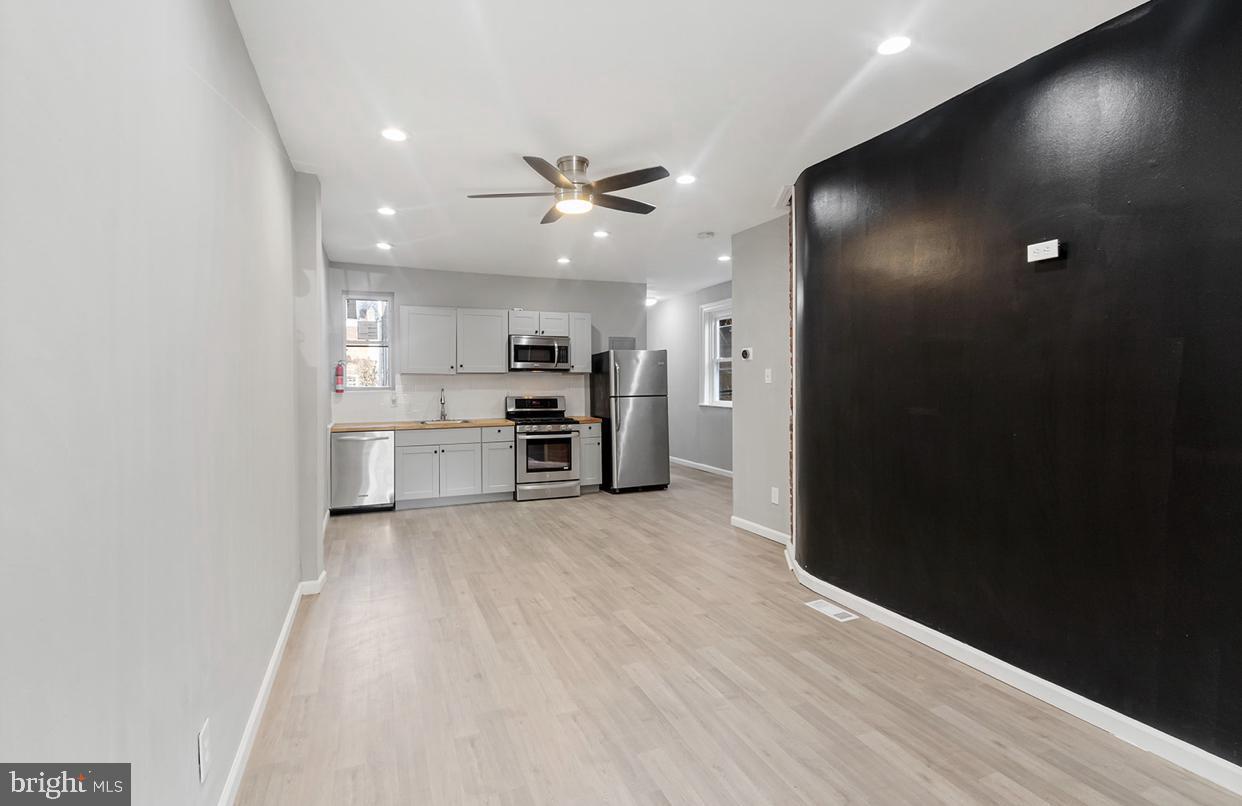 a view of kitchen with refrigerator and microwave