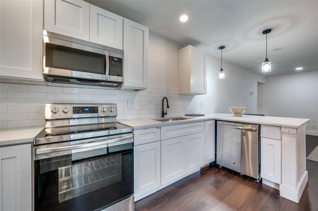 a kitchen with stainless steel appliances white cabinets and a stove top oven