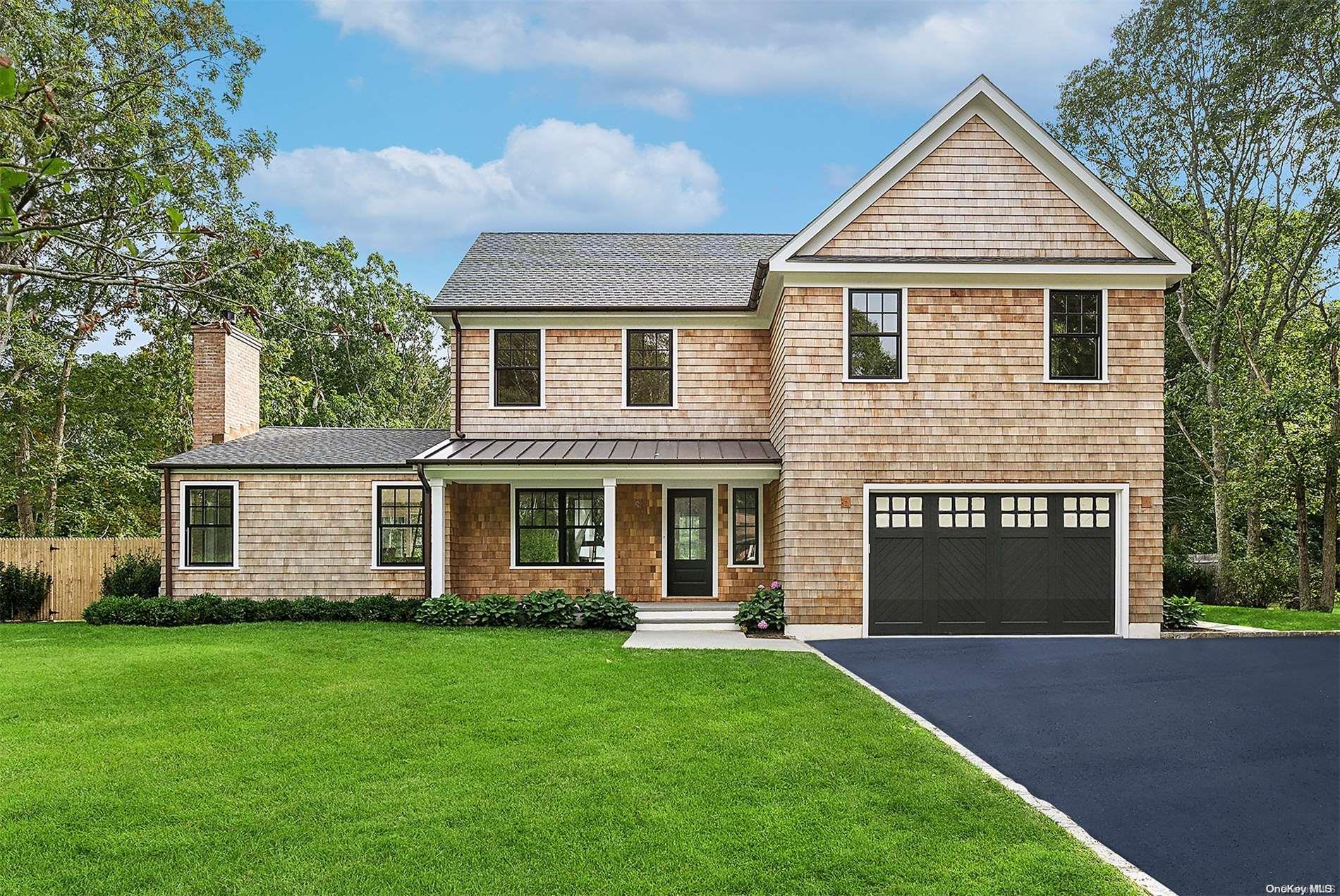 a front view of a house with a garden and yard