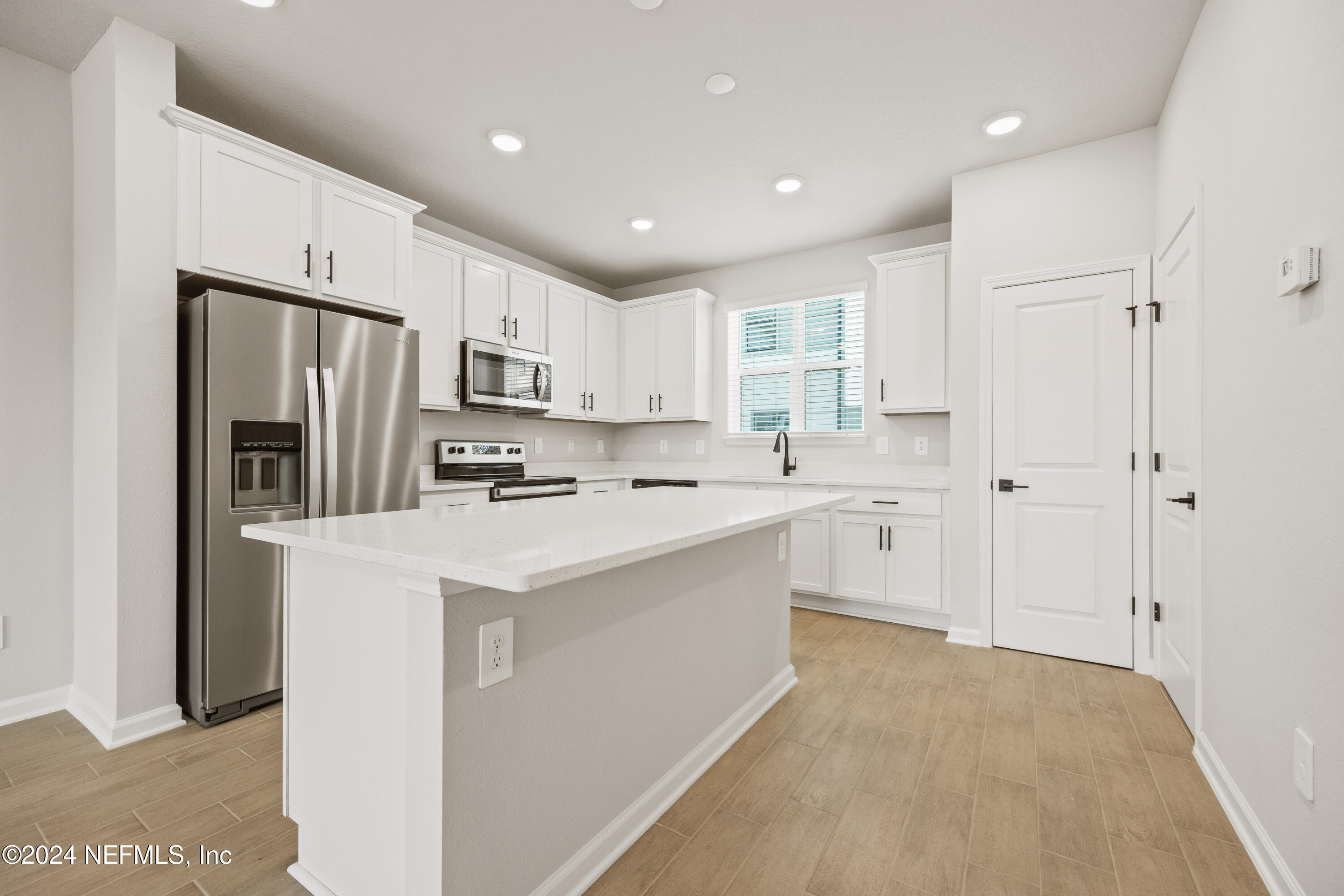 a kitchen with white cabinets and stainless steel appliances