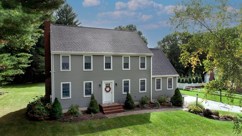 a front view of a house with a yard and trees