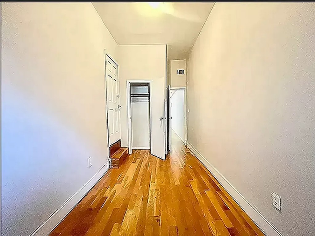 a view of a room with wooden floor and a ceiling fan