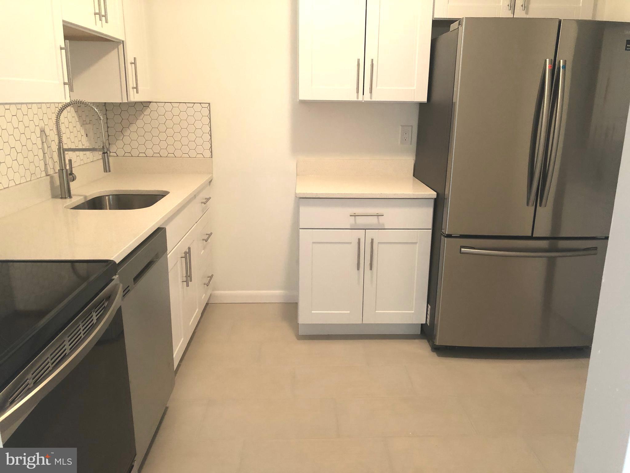 a kitchen with cabinets and a refrigerator