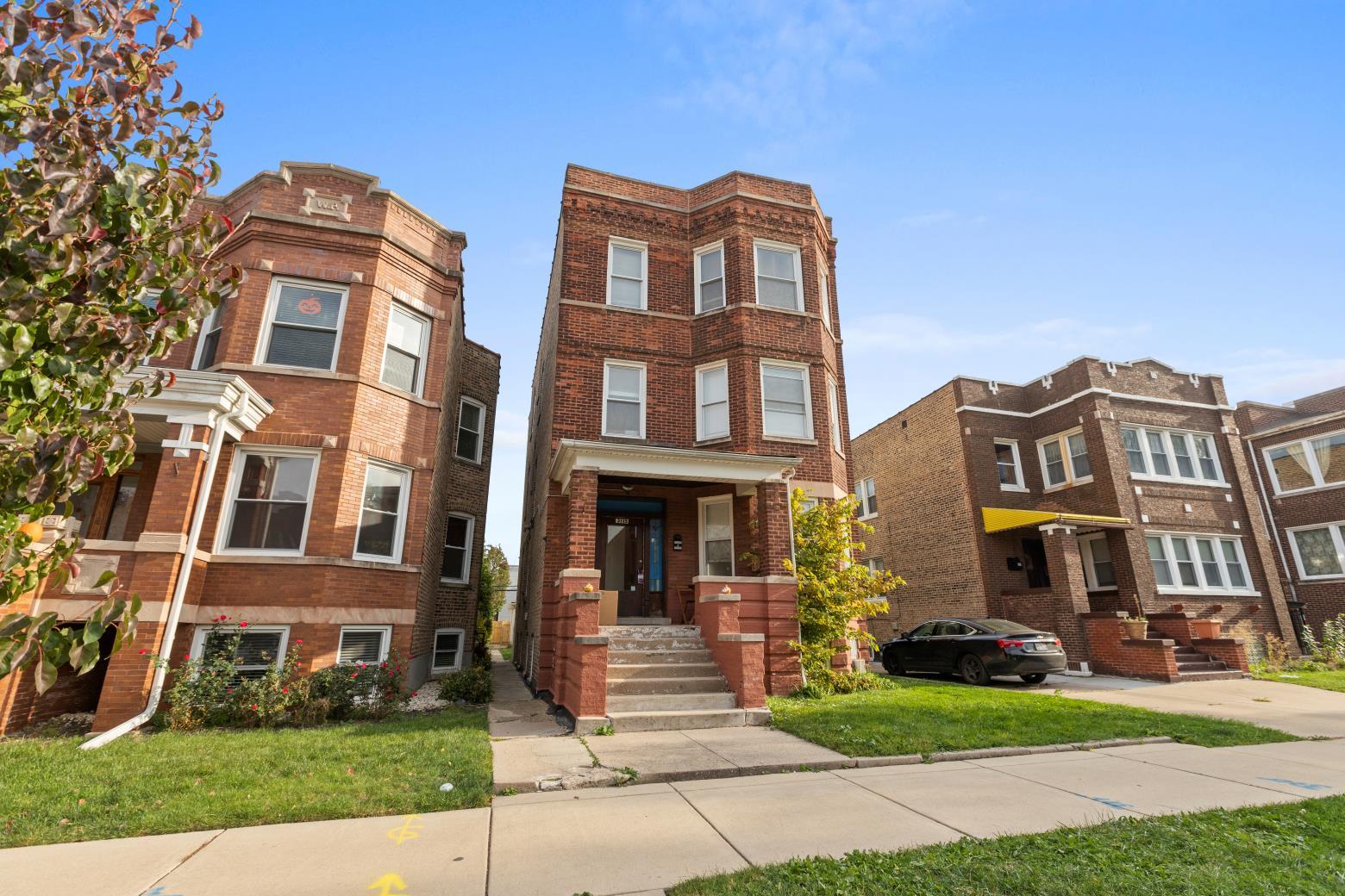 a front view of a residential apartment building with a yard