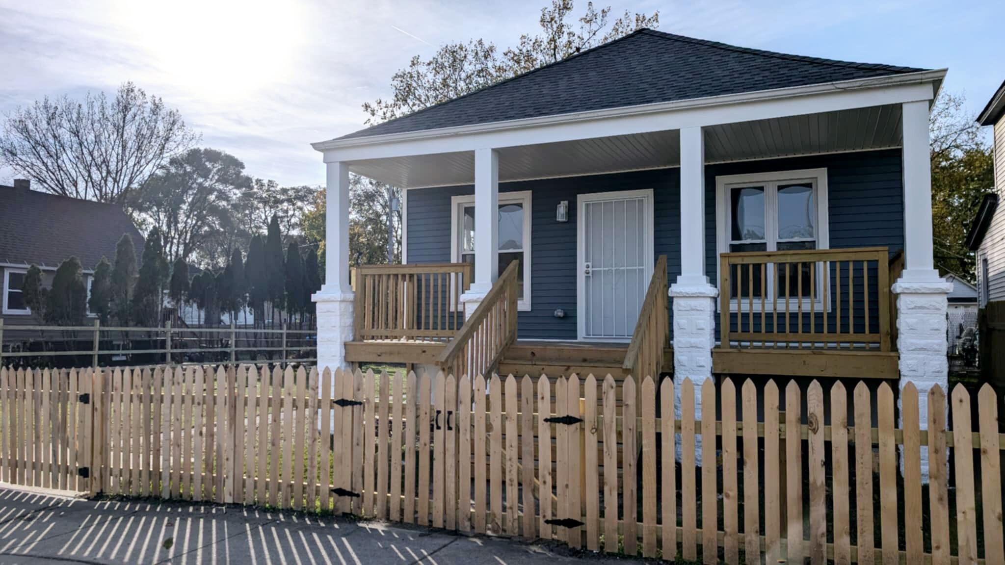 a view of a house with wooden fence