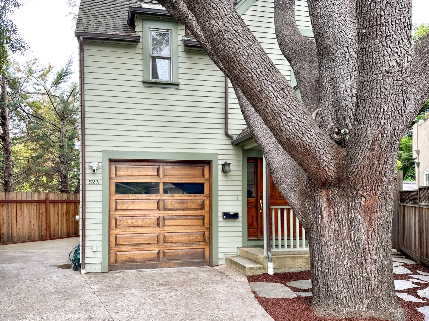 a front view of a house with a tree