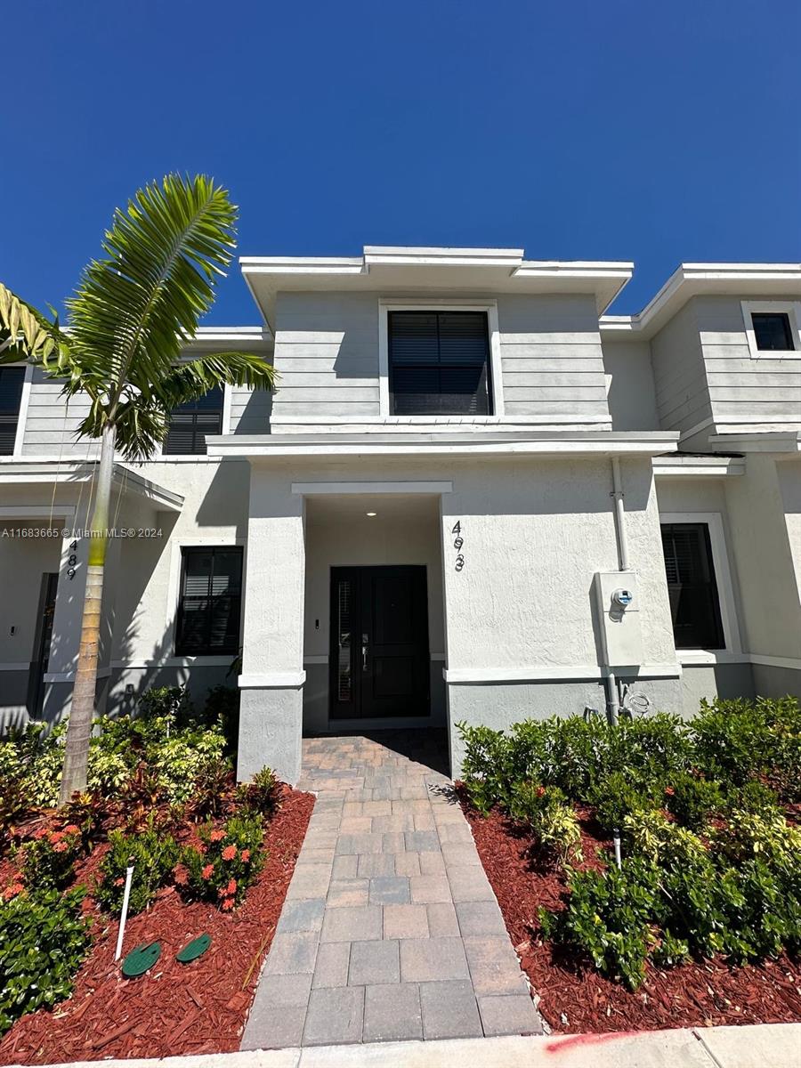 a front view of a house with plants