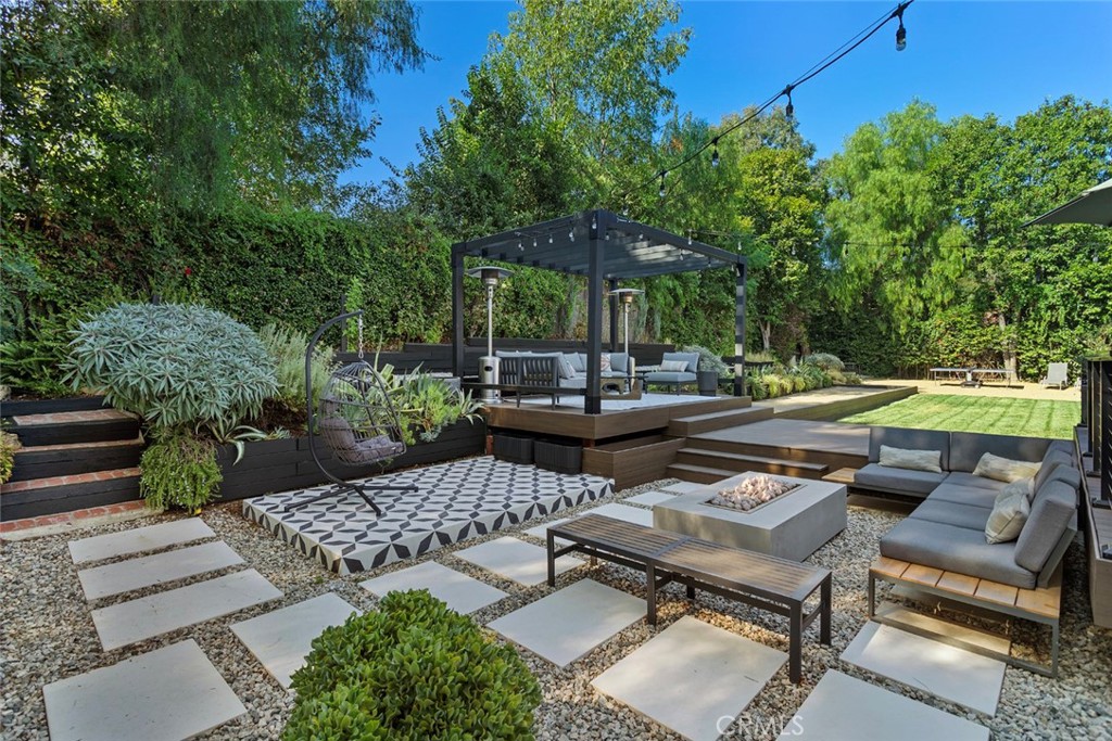 a backyard of a house with fire pit and outdoor seating