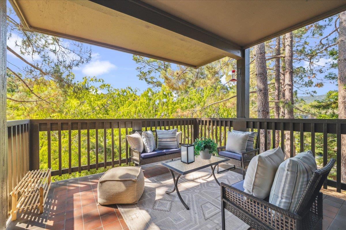 a balcony with wooden floor table and chairs