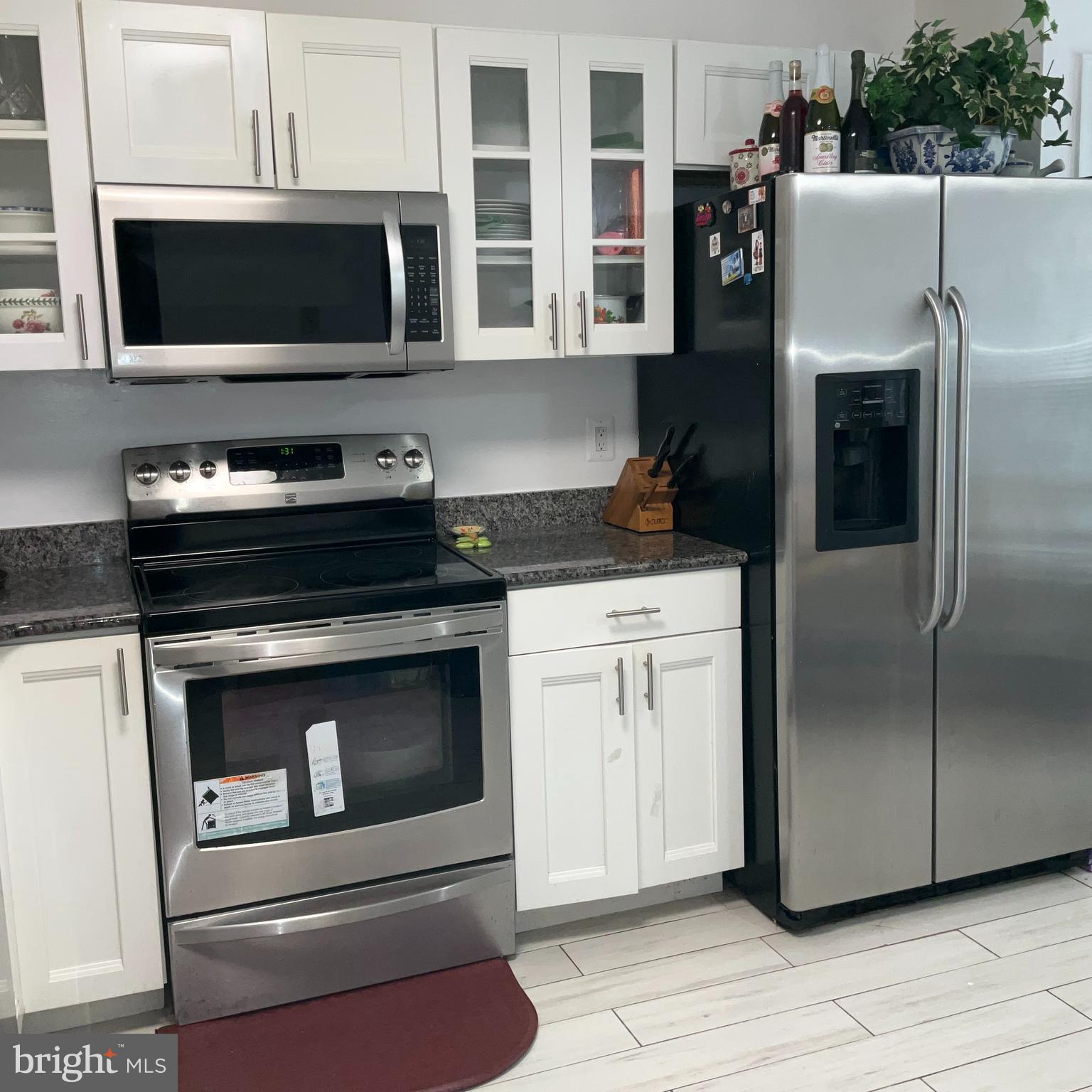 a kitchen with granite countertop white cabinets stainless steel appliances and counter space