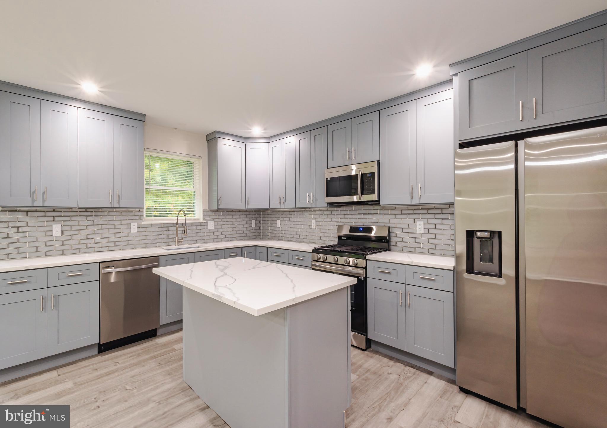 a kitchen with a sink stove a refrigerator and cabinets