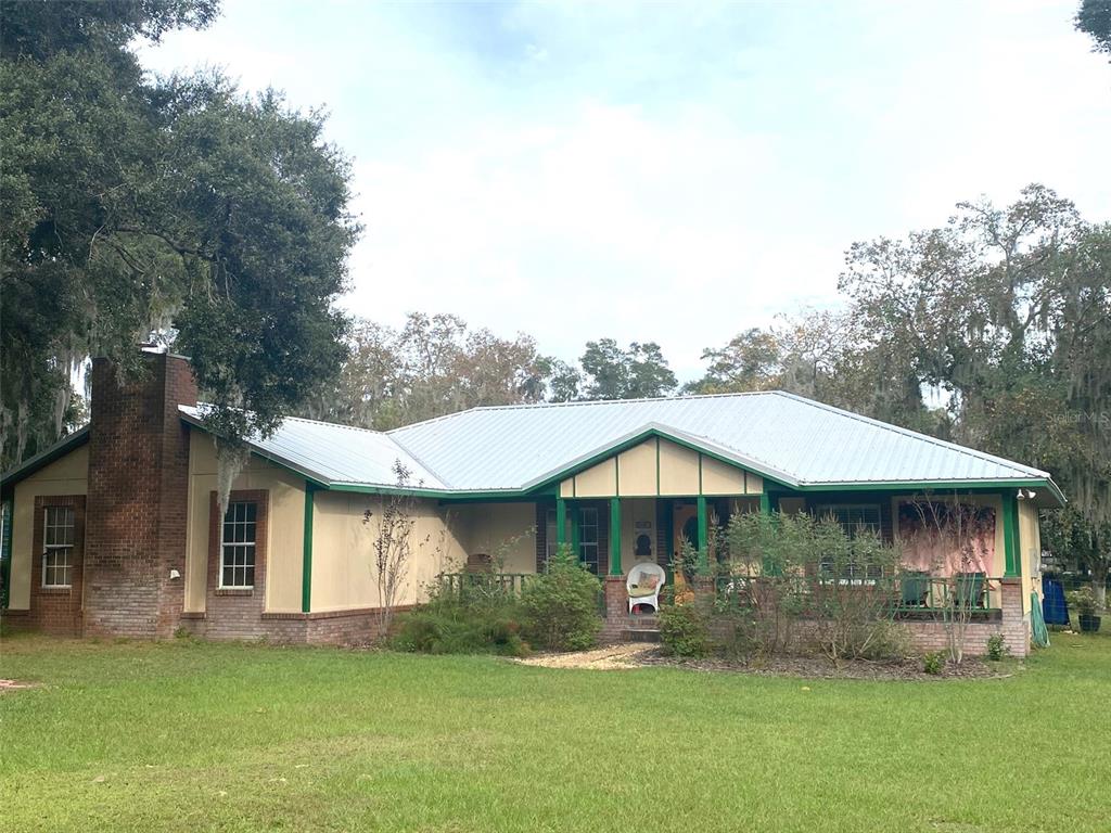 a front view of a house with a garden and trees