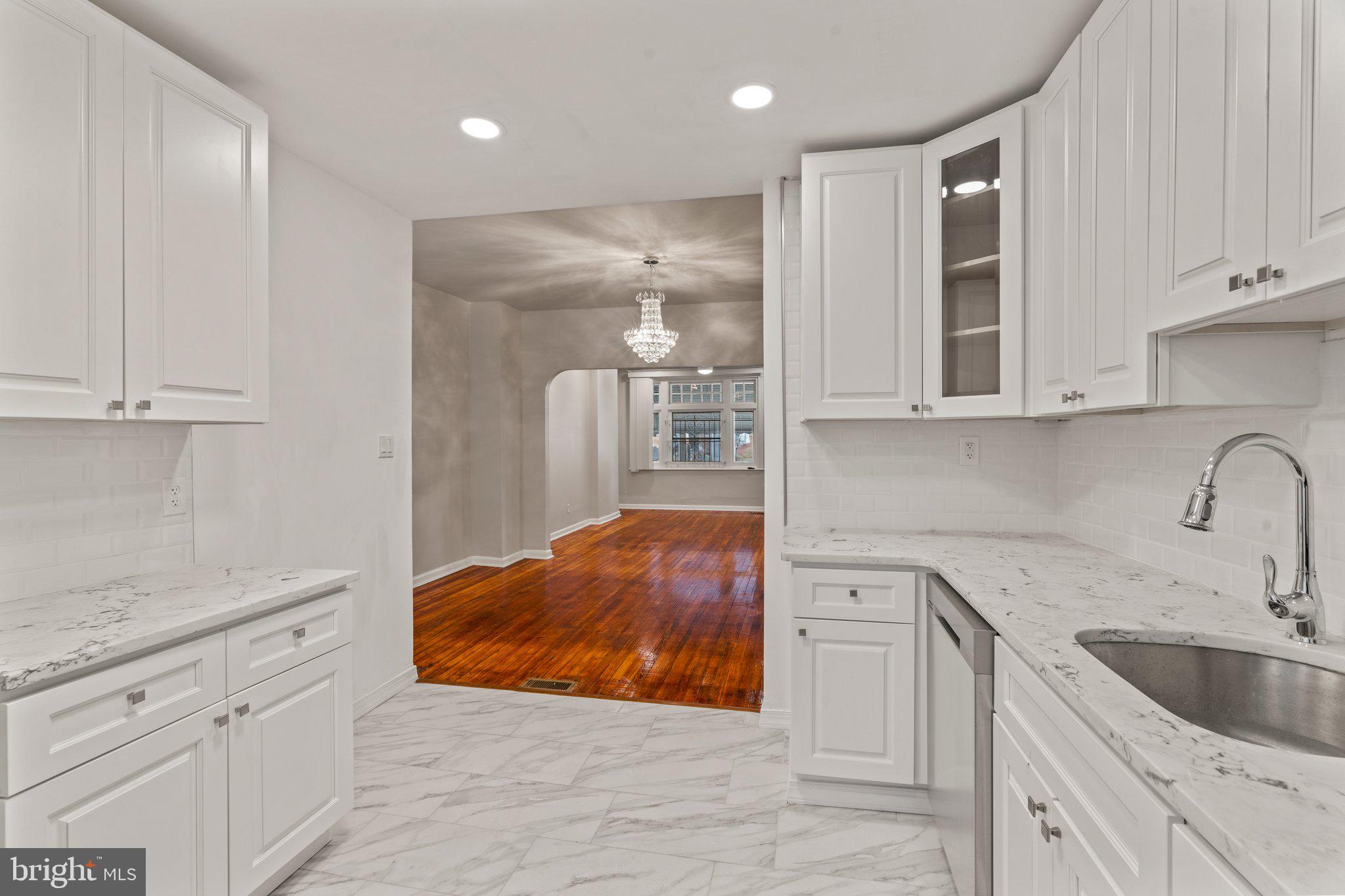 a kitchen with white cabinets and sink