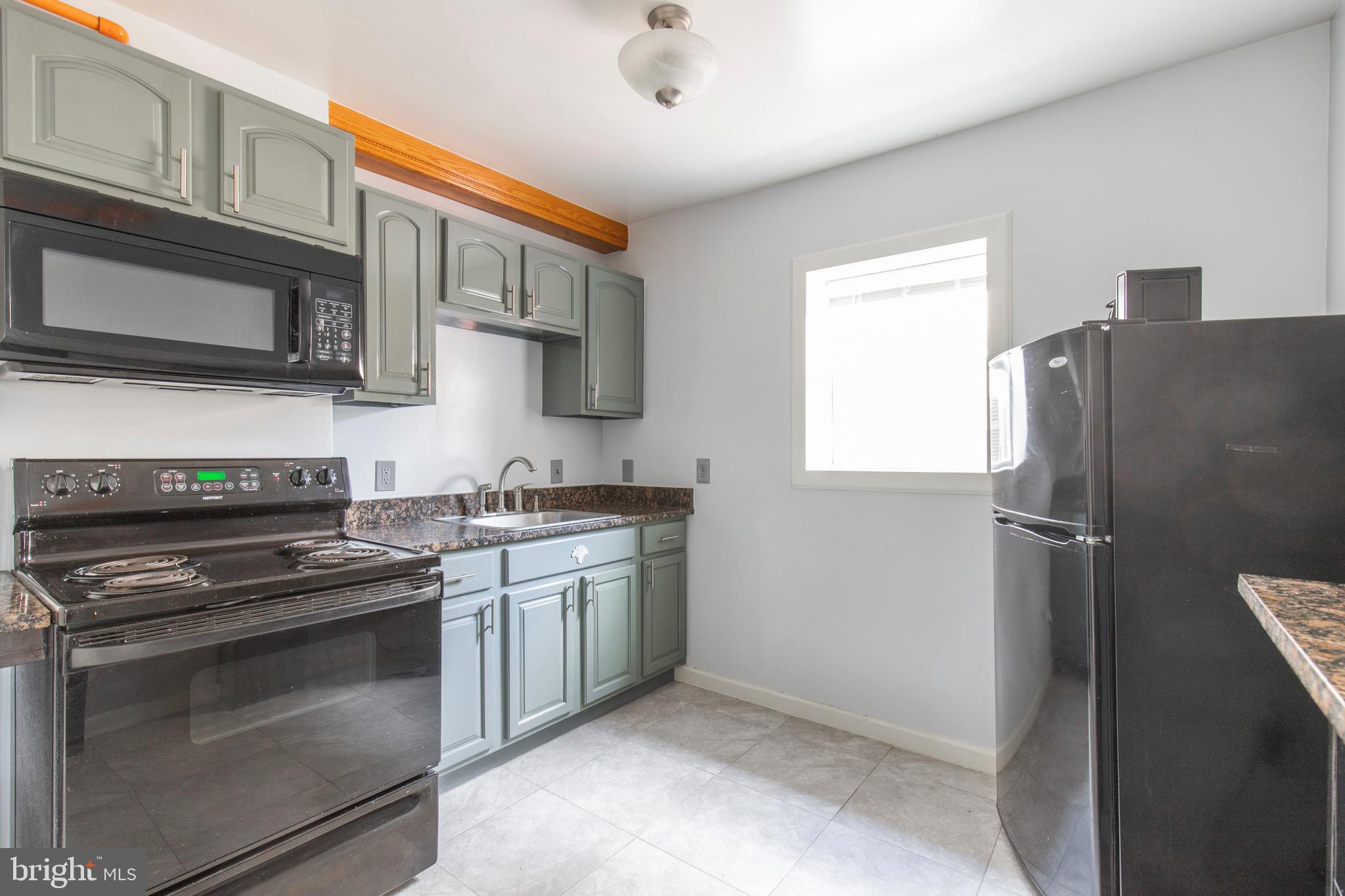 a kitchen with stainless steel appliances granite countertop a refrigerator stove and sink