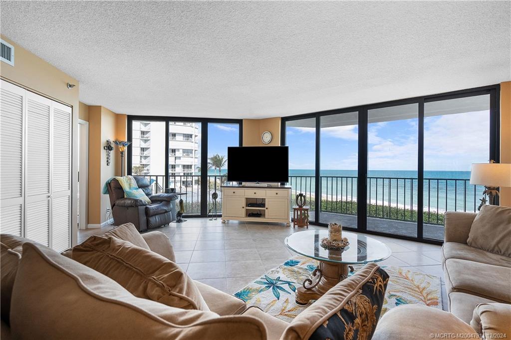 a living room with furniture a flat screen tv and a large window