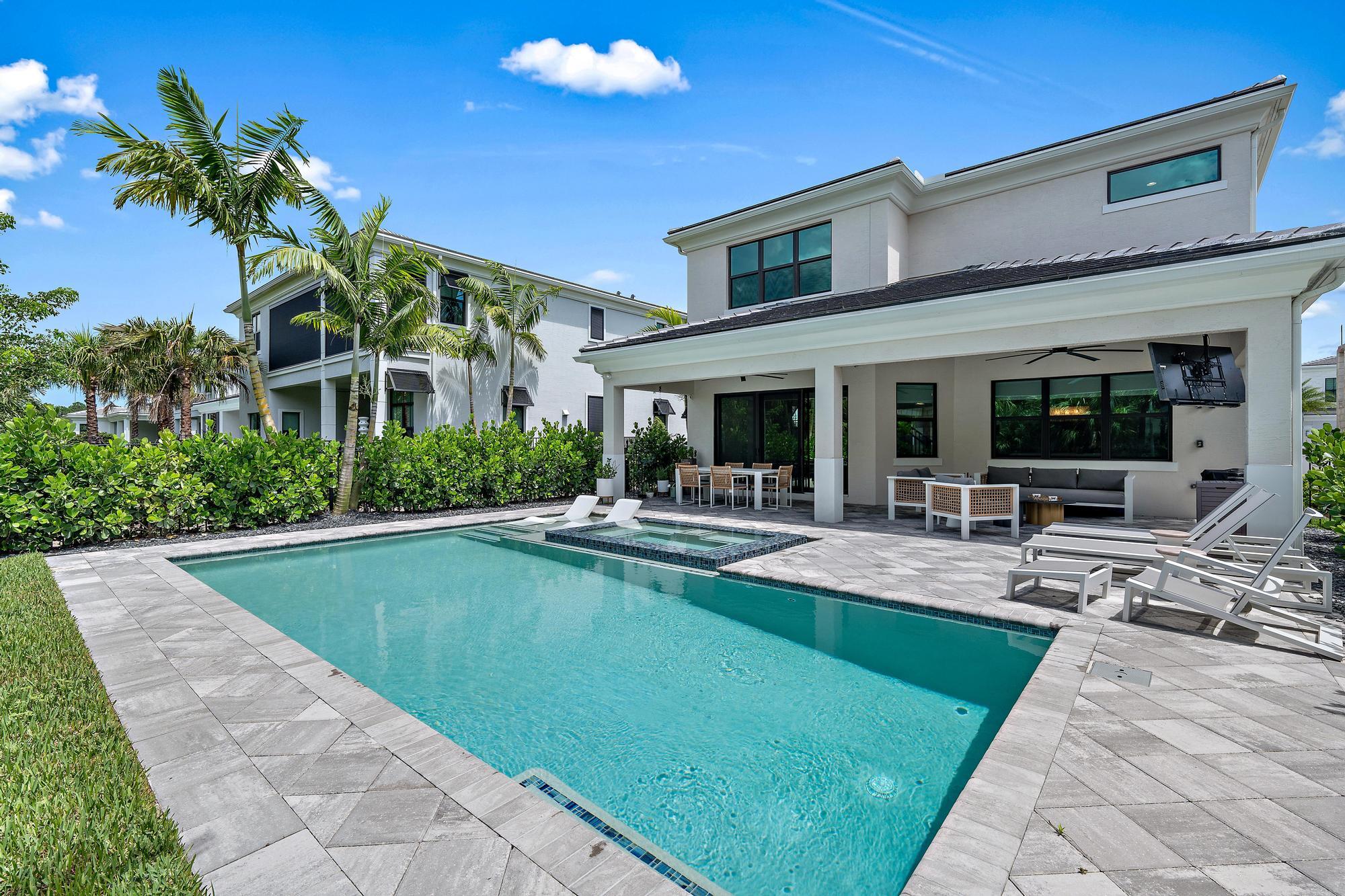 a view of a house with swimming pool and sitting area