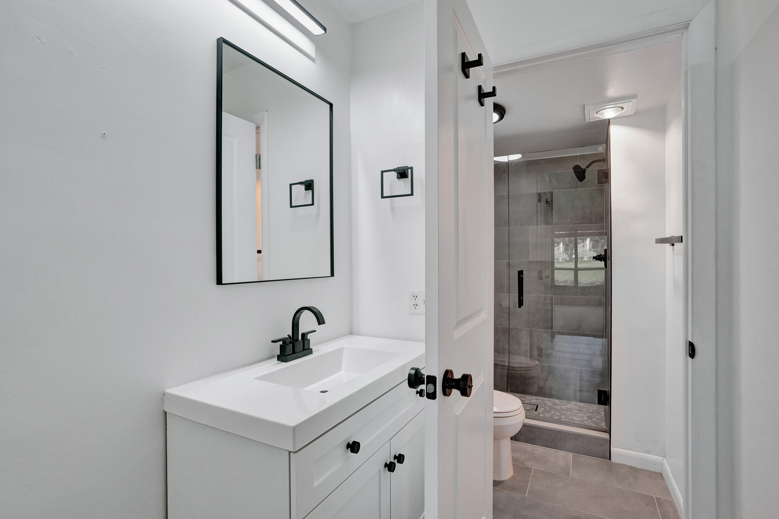 a bathroom with a sink toilet a mirror and shower