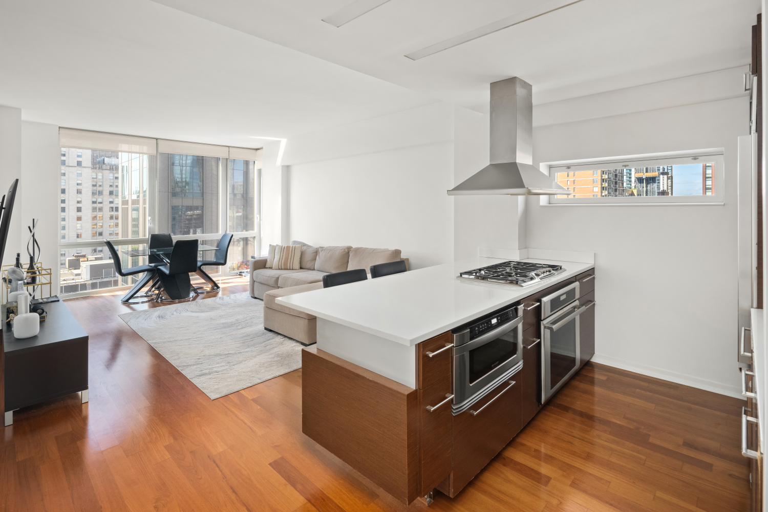 a view of living room kitchen with stainless steel appliances granite countertop a stove and a large window