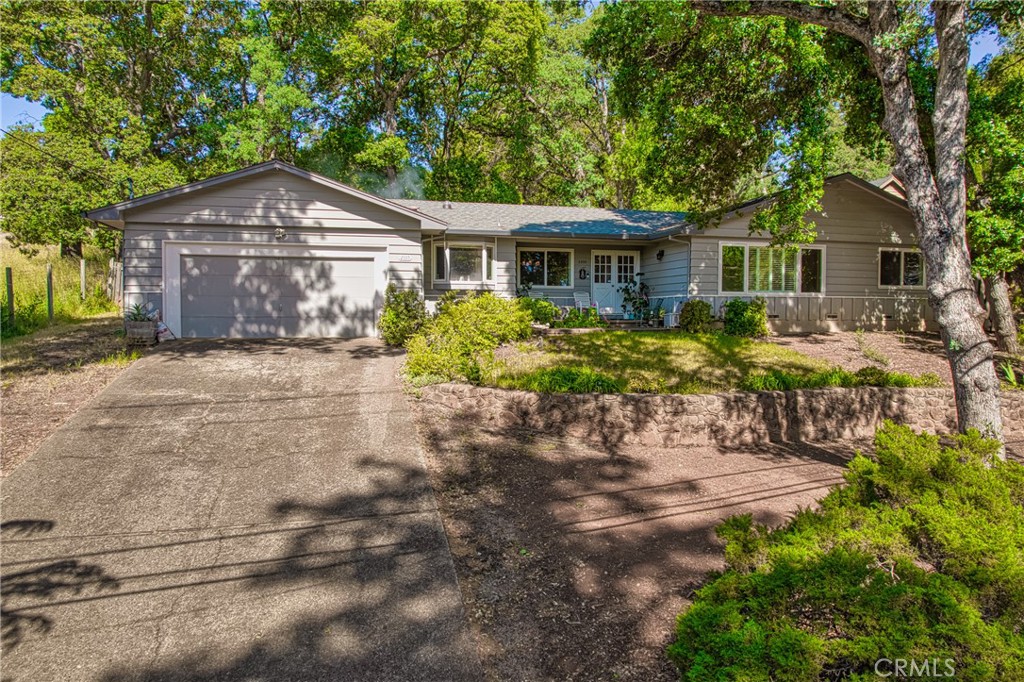 a front view of house with yard and trees around