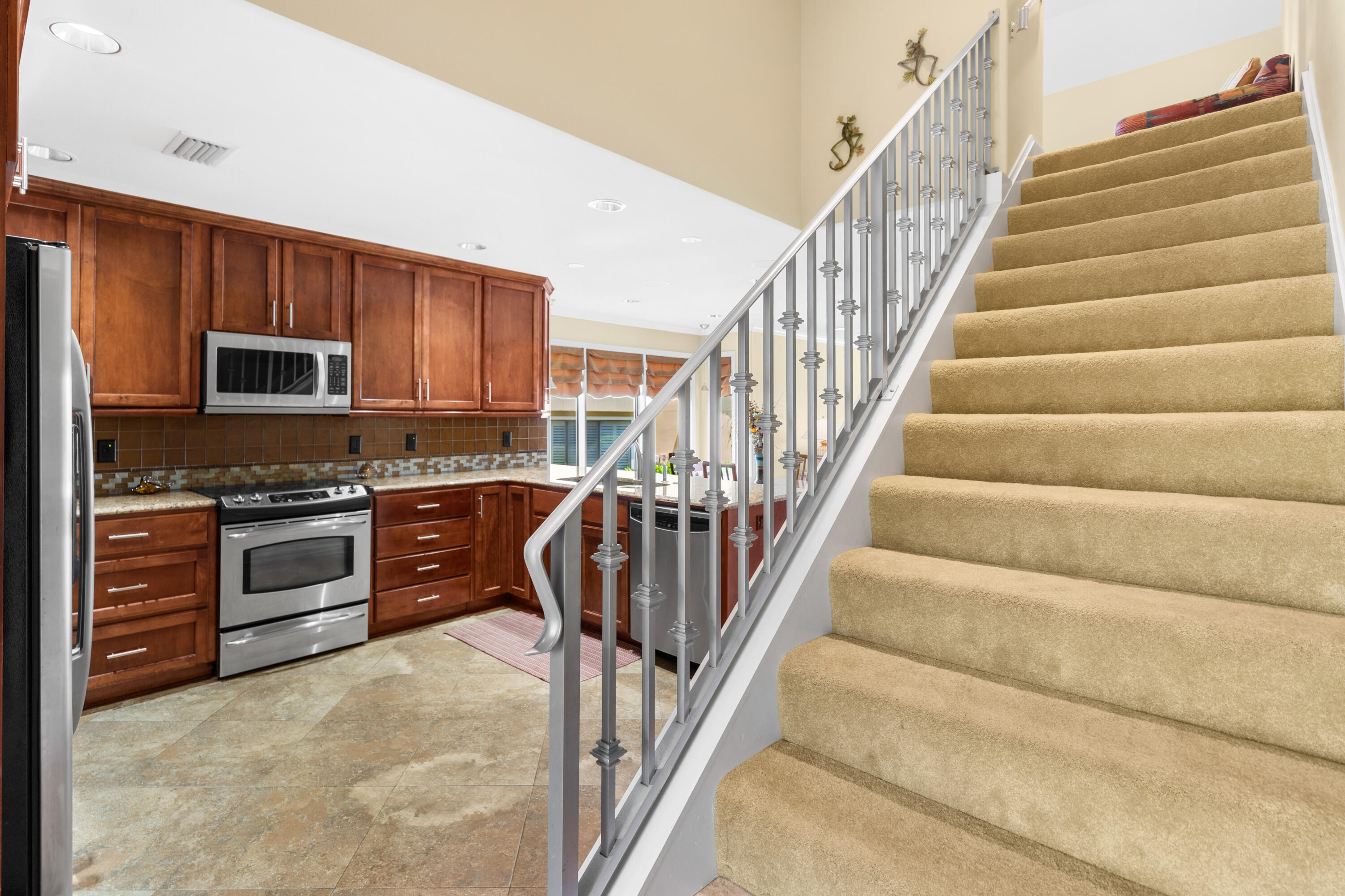 a kitchen with granite countertop a stove top oven a sink and a refrigerator