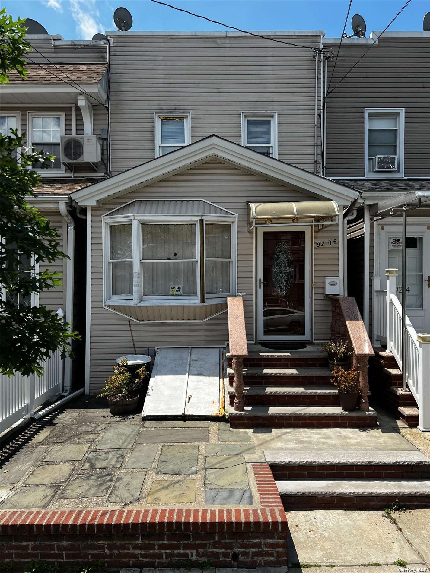 a view of a house with a small yard and wooden floor and fence