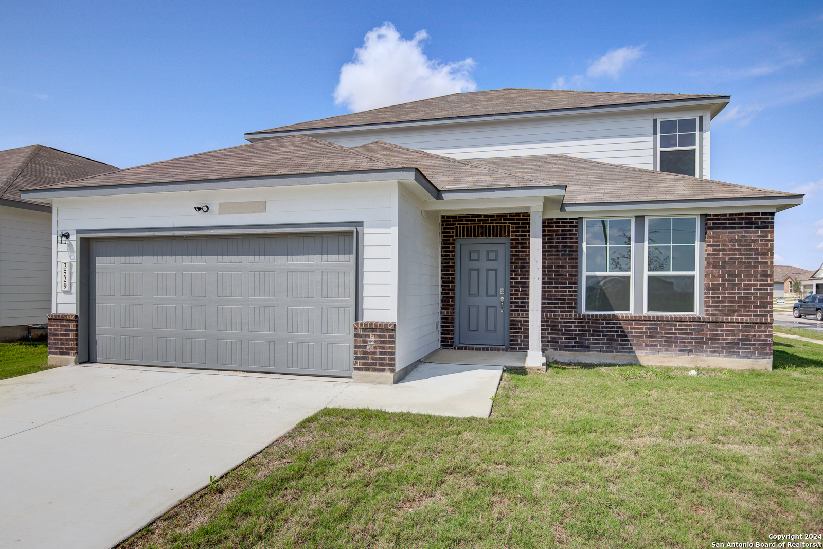 a front view of a house with a yard and garage