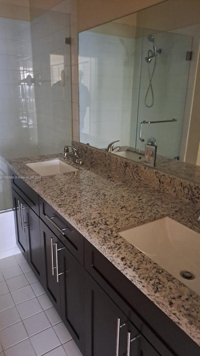 a bathroom with a granite countertop sink and mirror