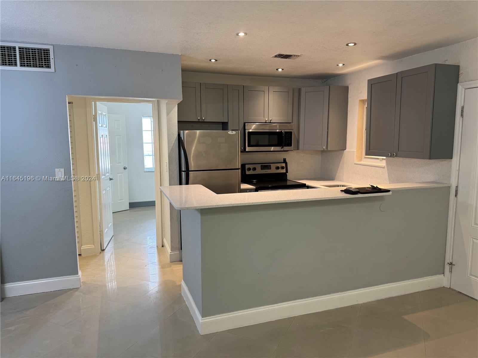 a kitchen with stainless steel appliances a refrigerator and a stove top oven