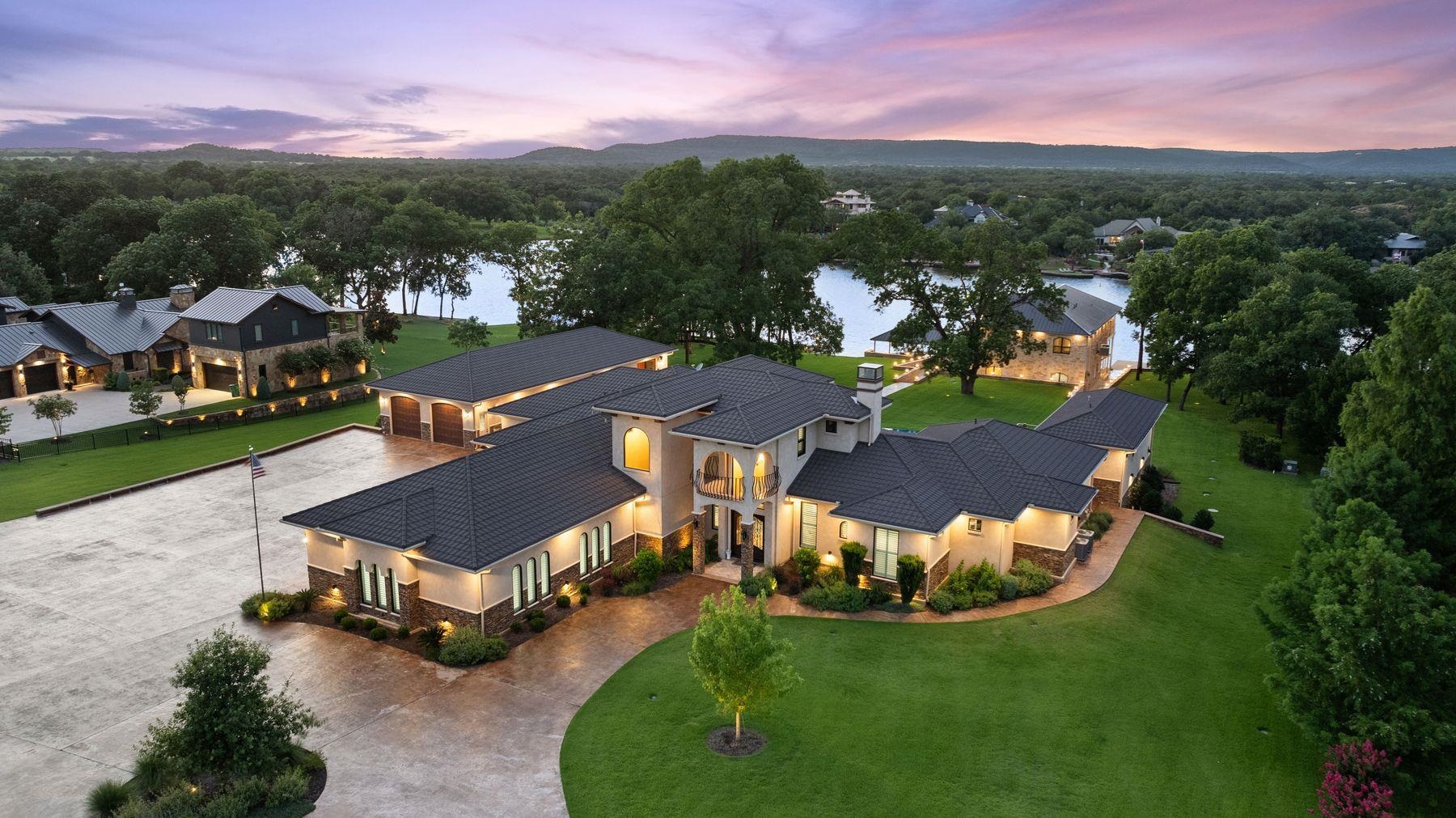 an aerial view of a house with a garden and lake view