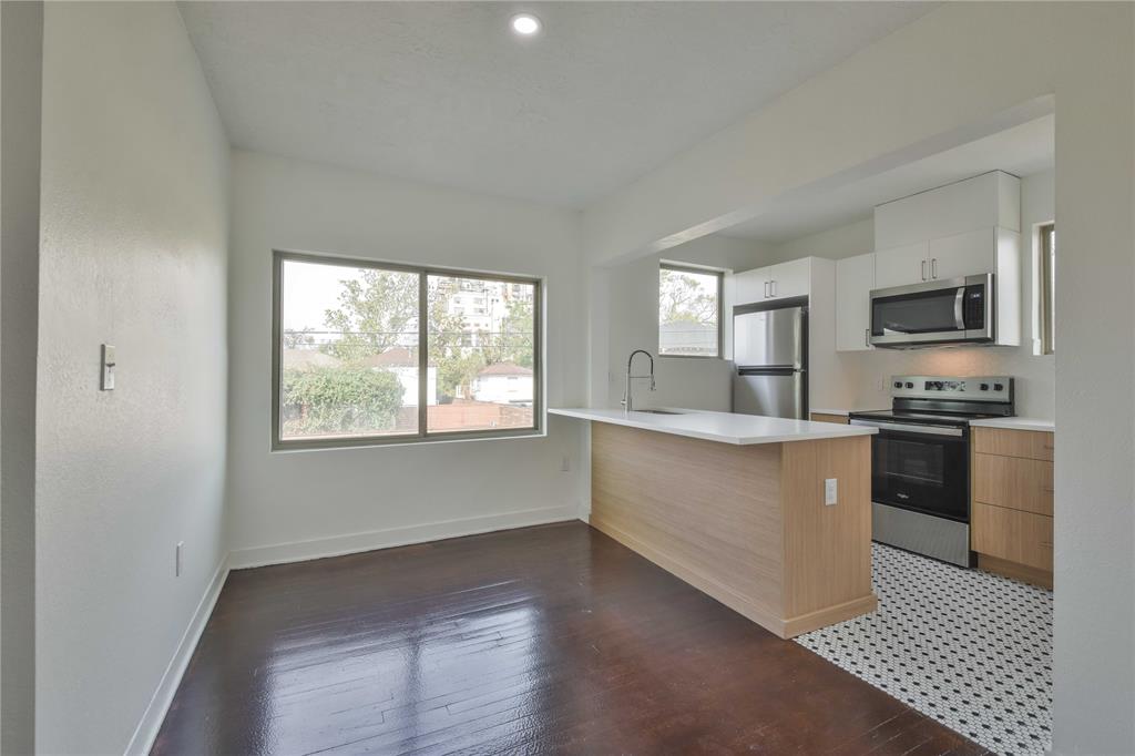 a kitchen with a refrigerator and a stove top oven