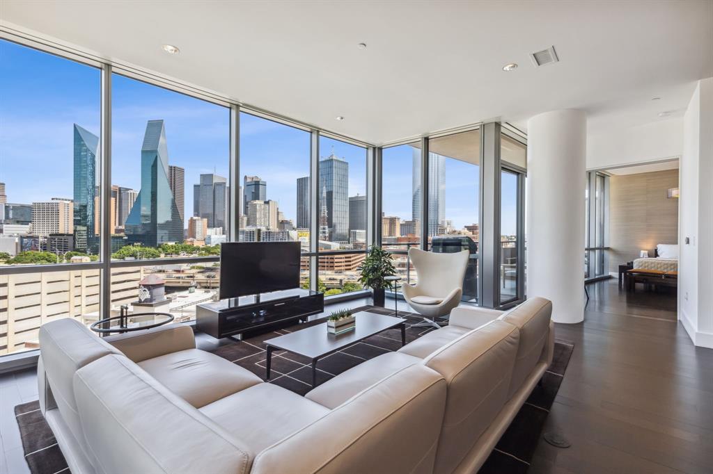 a living room with furniture a flat screen tv and a floor to ceiling window