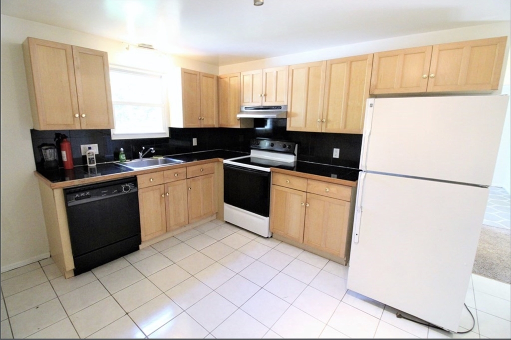 a kitchen with a sink a stove top oven and white stainless steel appliances